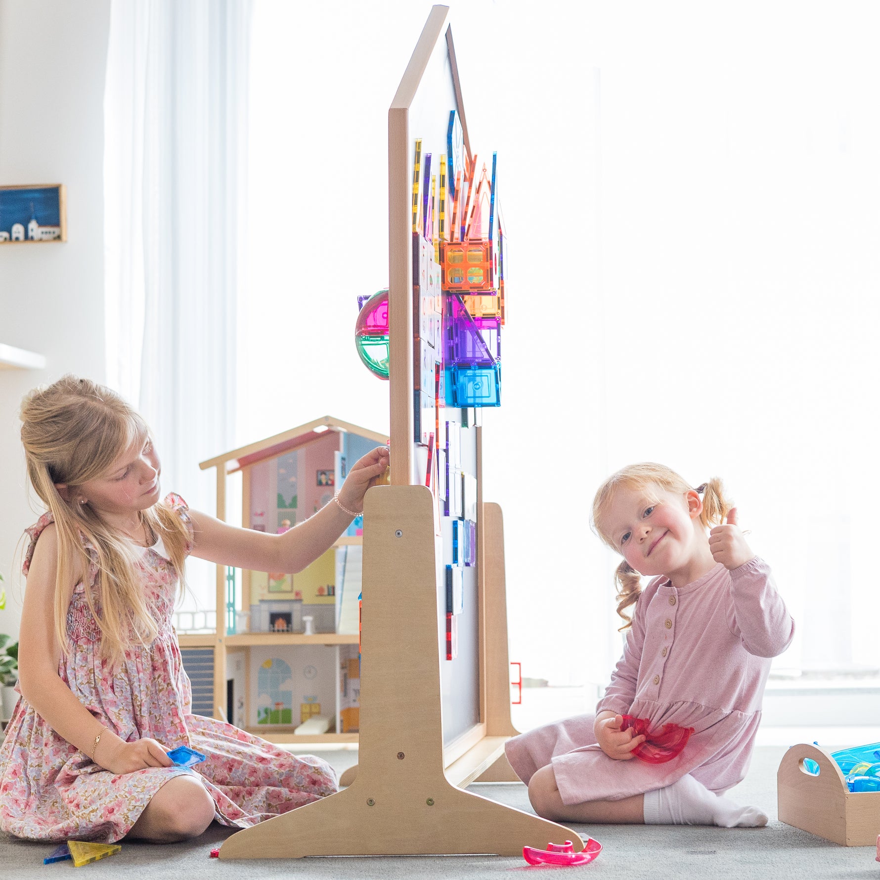 Children playing on either side of the learn & grow toys mutli-board sitting in a light filled playrom