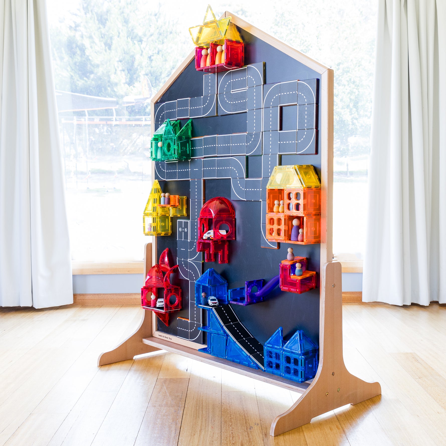 Magnetic tiles and road toppers sitting on blackboard of multi-board with stand on side