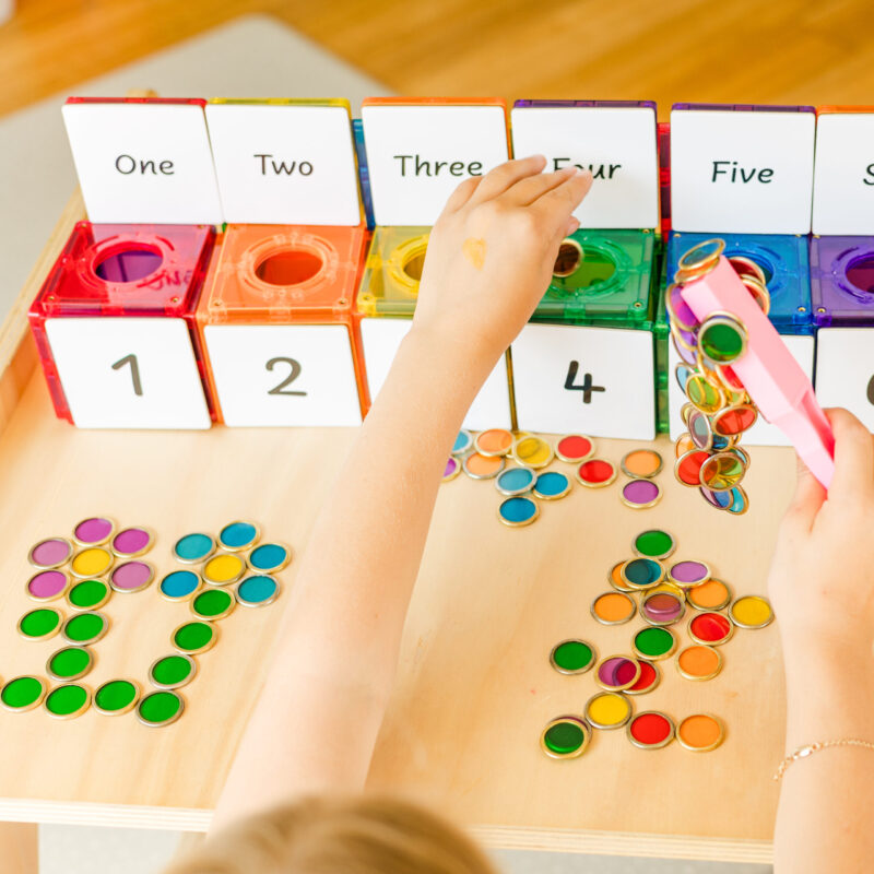 Child using chips and wands for number counting activity