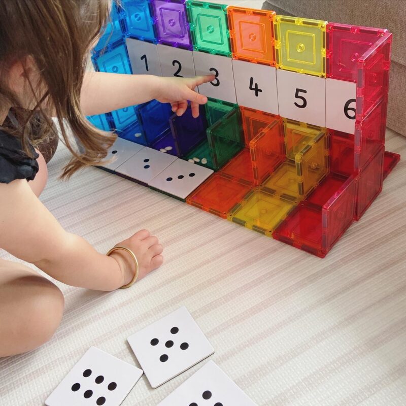 Child-playing-with-numeracy-toppers-on-magnetic-tiles