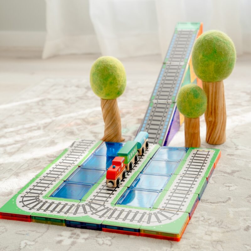 Learn and Grow Toys train toppers set up with Papoose trees in bright room