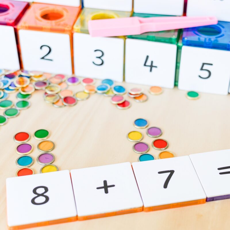 Metal rimmed counting chips with numeracy magnetic tile toppers being used