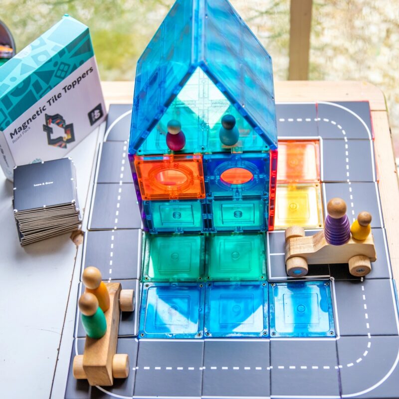 Road toppers with packaging sitting with blue magnetic tile house near window