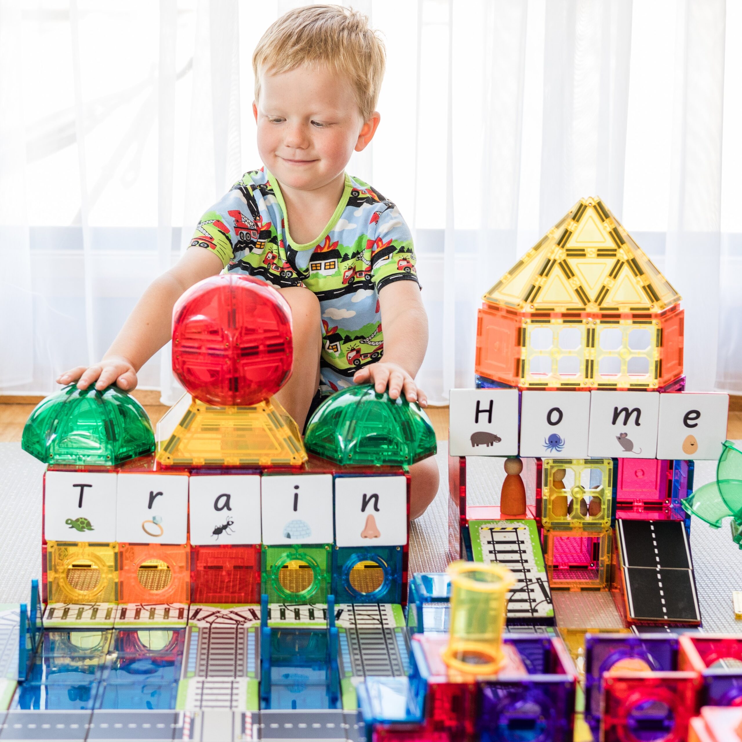 Child playing with dome and geometry tile packs in a playroom