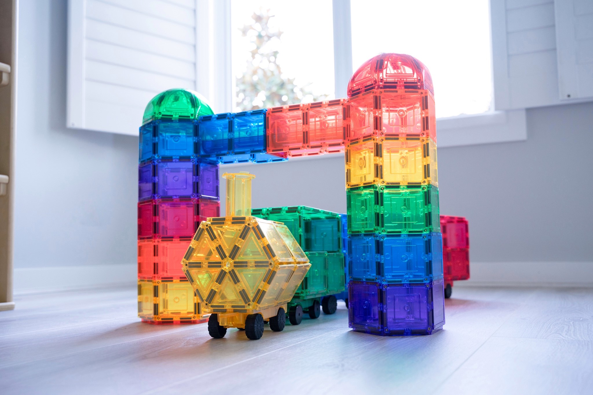 Learn and Grow magnetic tile train and dome build in playroom with sunlight coming through the window