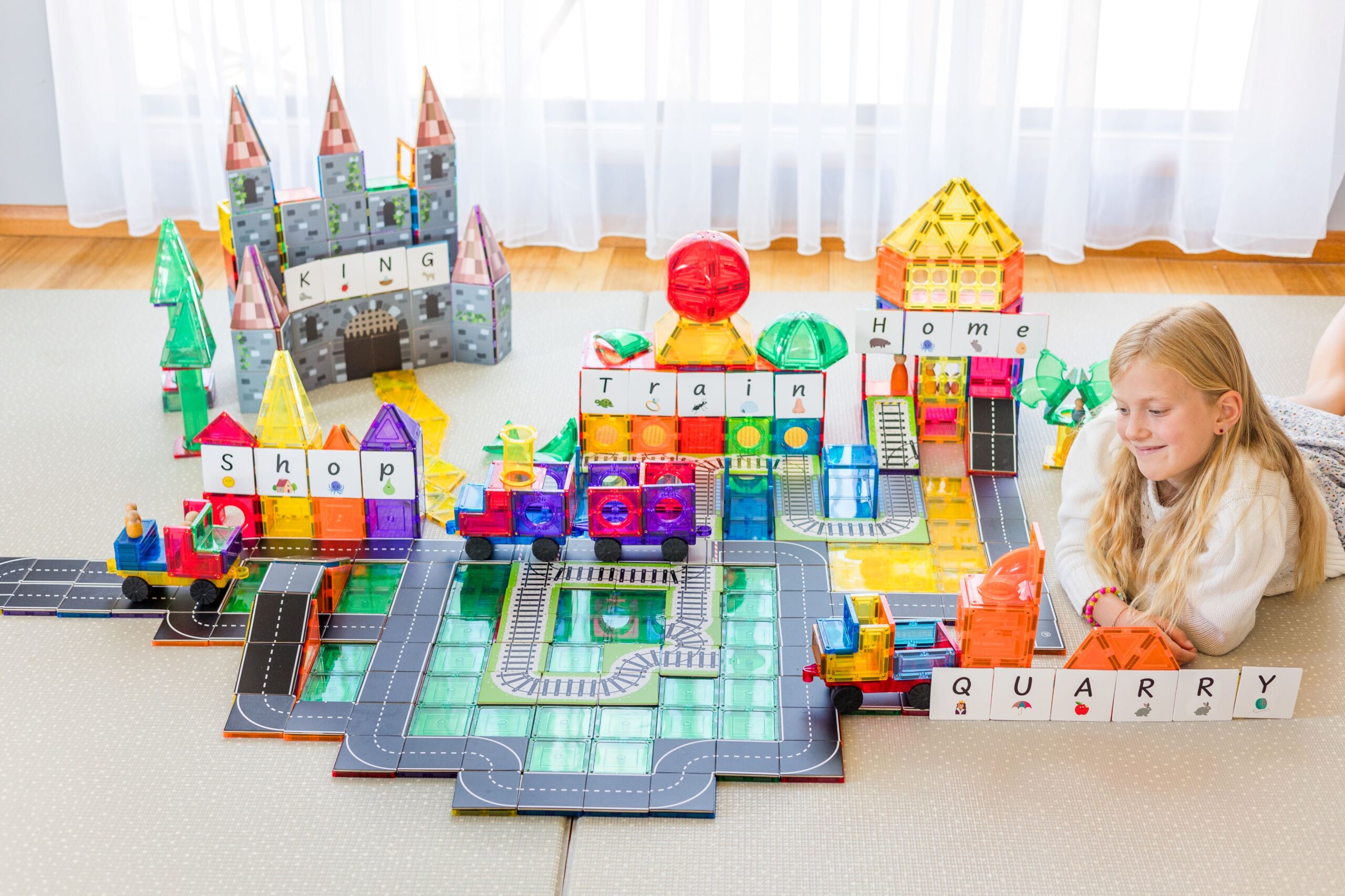 A child with a full display of Learn & Grow Toys including tiles and tile toppers