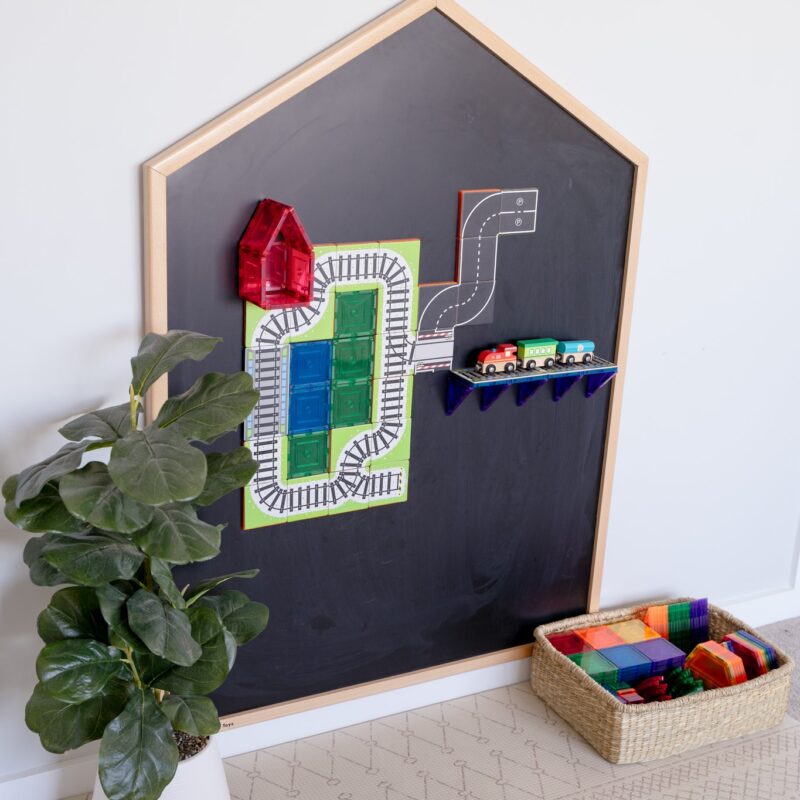 Learn & Grow Toys Multi-Board on wall in playroom with road and train toppers on board