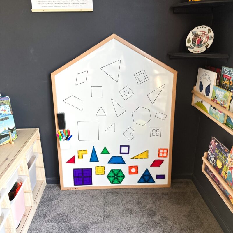Learn & Grow Toys Multi-Board whiteboard on wall in playroom with shapes and tiles on the whiteboard